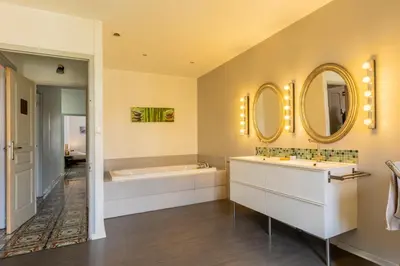 a bathroom with two sinks and a tub and mirrors at Maison de Vacances 8 à 15 pers à proximité du Canal du Midi in Sallèles-dʼAude