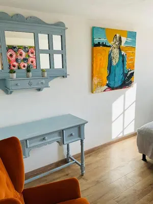 a living room with a table and a painting on the wall at Hôte Labyrinthe sur la place chambres d, hôtes , calme ,Netflix in Mirepoix