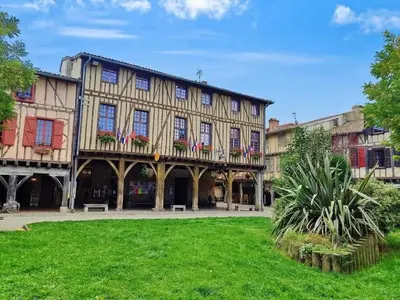 an old building with american flags in the courtyard at Hôte Labyrinthe sur la place chambres d, hôtes , calme ,Netflix in Mirepoix