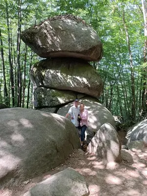 a man and woman standing next to a stack of rocks at La Gorge in Lacrouzette