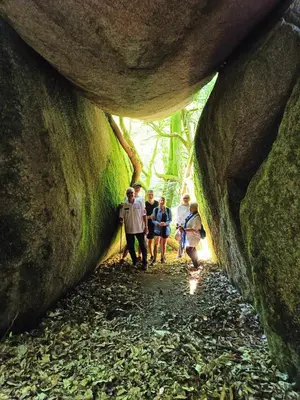 a group of people walking through a moss covered cave at La Gorge in Lacrouzette