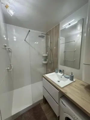 a white bathroom with a shower and a sink at Appartement RDC vue mer - GRUISSAN in Gruissan