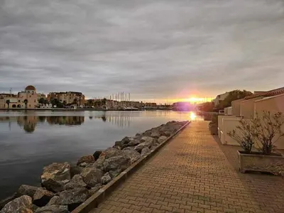 a view of a river with the sun setting in the distance at Appartement RDC vue mer - GRUISSAN in Gruissan