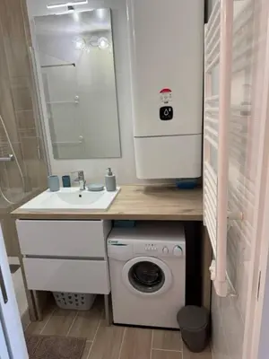 a small bathroom with a washing machine and a sink at Appartement RDC vue mer - GRUISSAN in Gruissan