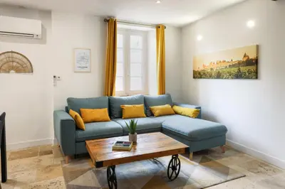 a living room with a blue couch and a table at Le refuge de Saint-Gimer in Carcassonne