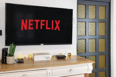 a tv on a wall with a netflix sign on it at Le refuge de Saint-Gimer in Carcassonne