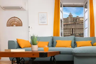 a living room with a blue couch and orange pillows at Le refuge de Saint-Gimer in Carcassonne