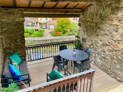a patio with a table and chairs on a deck at Maison CABARET Luxury 4 Star Air Conditioned 100m to 4 Cathar Châteaux Lastours private Terrasse with views!! in Lastours