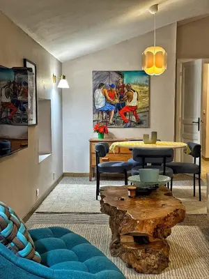 a living room with a table and a painting on the wall at Maison CABARET Luxury 4 Star Air Conditioned 100m to 4 Cathar Châteaux Lastours private Terrasse with views!! in Lastours