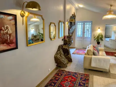 a living room with a couch and mirrors on the wall at Maison CABARET Luxury 4 Star Air Conditioned 100m to 4 Cathar Châteaux Lastours private Terrasse with views!! in Lastours