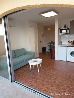 a living room with a couch and a table at Studio avec accès direct sur le port de Gruissan in Gruissan