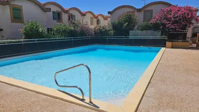 a large swimming pool with a hand rail in front of a building at Studio avec accès direct sur le port de Gruissan in Gruissan