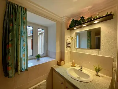 a bathroom with a sink and a mirror at Centre of Olonzac, 2 bedrooms & private sunny rooftop terrace in Olonzac