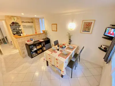 a dining room with a table and chairs in a room at Centre of Olonzac, 2 bedrooms & private sunny rooftop terrace in Olonzac