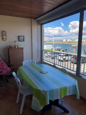a dining room with a table and a view of the water at Appart T2 vue imprenable sur le canal et la mer in Port-la-Nouvelle
