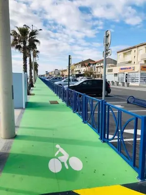 a green sidewalk with a bike sign on it at Appart T2 vue imprenable sur le canal et la mer in Port-la-Nouvelle