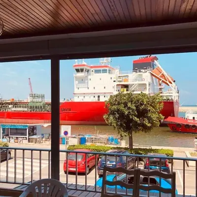 a large red and white ship in the water at Appart T2 vue imprenable sur le canal et la mer in Port-la-Nouvelle