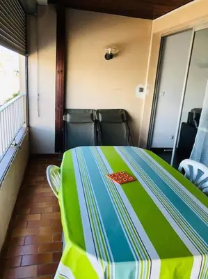 a room with a green and blue table with chairs at Appart T2 vue imprenable sur le canal et la mer in Port-la-Nouvelle