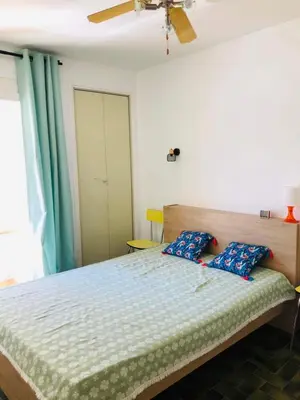 a bedroom with a bed and a ceiling fan at Appart T2 vue imprenable sur le canal et la mer in Port-la-Nouvelle