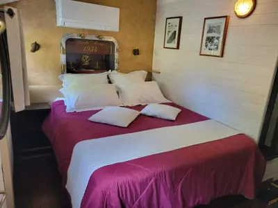a bedroom with a large bed with pillows at Péniche Mirage-chambre d'hôtes in Carcassonne