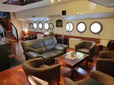 a living room with a leather couch and chairs at Péniche Mirage-chambre d'hôtes in Carcassonne