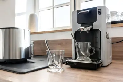 a coffee maker and two glasses on a counter at Le 11 JACUZZI avec Terrasses Clim Netflix Parking in Carcassonne