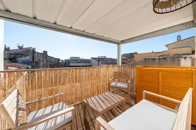a balcony with chairs and tables on a building at Le 11 JACUZZI avec Terrasses Clim Netflix Parking in Carcassonne