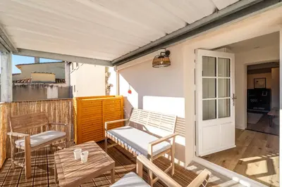 a porch with chairs and a bench and a table at Le 11 JACUZZI avec Terrasses Clim Netflix Parking in Carcassonne