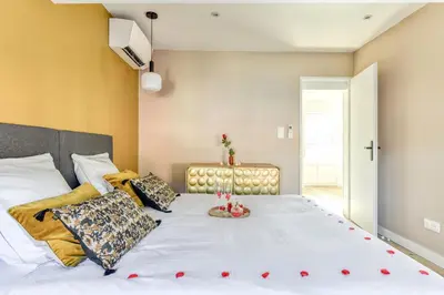 a bedroom with a large white bed with red hearts on it at Le 11 JACUZZI avec Terrasses Clim Netflix Parking in Carcassonne
