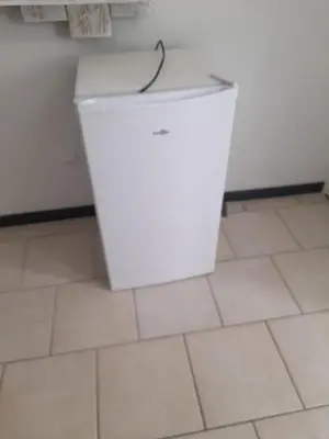a white refrigerator in a room with a tile floor at Chez Sabine et Patrick in Narbonne