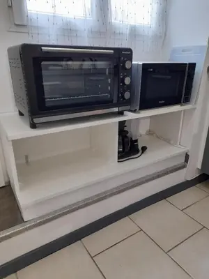 a microwave and a toaster oven on a shelf at Chez Sabine et Patrick in Narbonne