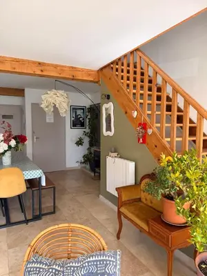 a living room with a staircase and a table at Maison 6 places, en plein cœur de l’Ariège, proche ski et nature in Lesparrou