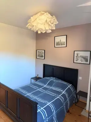 a bedroom with a bed with a blue comforter at Maison 6 places, en plein cœur de l’Ariège, proche ski et nature in Lesparrou