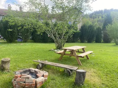 a picnic table and a fire pit in a yard at Maison 6 places, en plein cœur de l’Ariège, proche ski et nature in Lesparrou