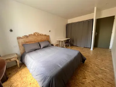 a bedroom with a large bed and a table at Au pied de la Cité in Carcassonne