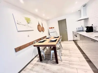 a kitchen with a wooden table and some chairs at Au pied de la Cité in Carcassonne