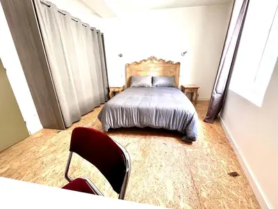 a bedroom with a bed and chairs in it at Au pied de la Cité in Carcassonne