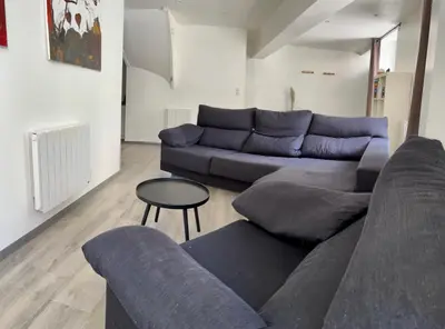 a living room with a blue couch and a table at Au pied de la Cité in Carcassonne