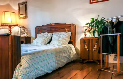 a bedroom with a bed and two night stands at Maison charmante à Aignes avec jardin et barbecue in Aignes