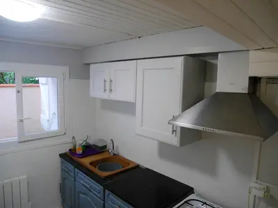 a small kitchen with a sink and a stove at Maison charmante à Aignes avec jardin et barbecue in Aignes