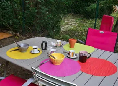 a table with plates and cups on top of it at Maison charmante à Aignes avec jardin et barbecue in Aignes