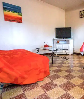 a room with a bed and a tv and a table at Maison charmante à Aignes avec jardin et barbecue in Aignes