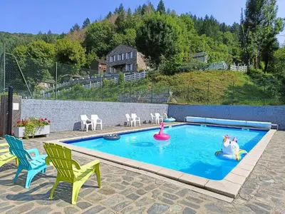 a swimming pool with a toy unicorn and two chairs at La Vallée in Lacrouzette
