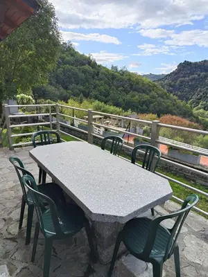 a table and chairs with a view of the mountains at La Vallée in Lacrouzette
