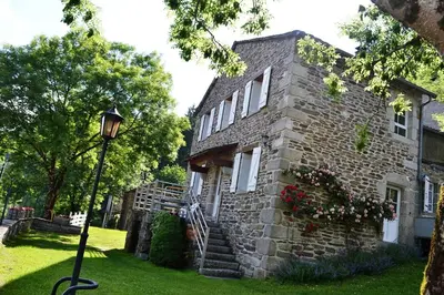 an old stone house with a street light in front of it at La Vallée in Lacrouzette