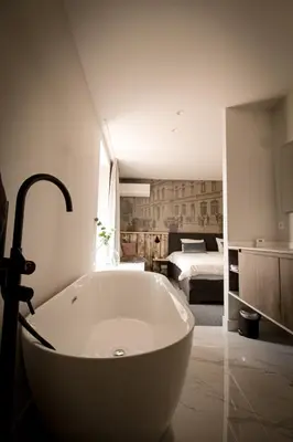 a white bath tub in a bathroom with a bedroom at Vins de Dagne in Montlaur
