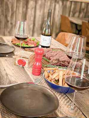 a table with two glasses of wine and a plate of food at Vins de Dagne in Montlaur