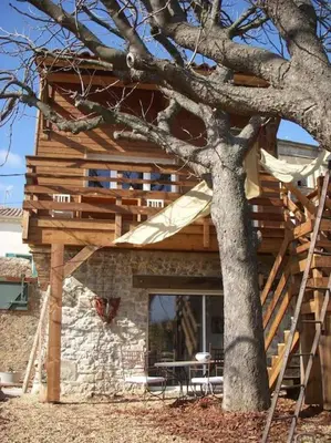 a house under construction next to a tree at Un havre de paix in Aigues-Vives