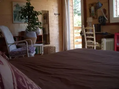 a bedroom with a bed and two chairs and a table at Un havre de paix in Aigues-Vives