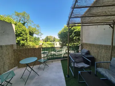 a patio with a table and a chair and a table at Le Jungle Appart, centre ville Narbonne in Narbonne